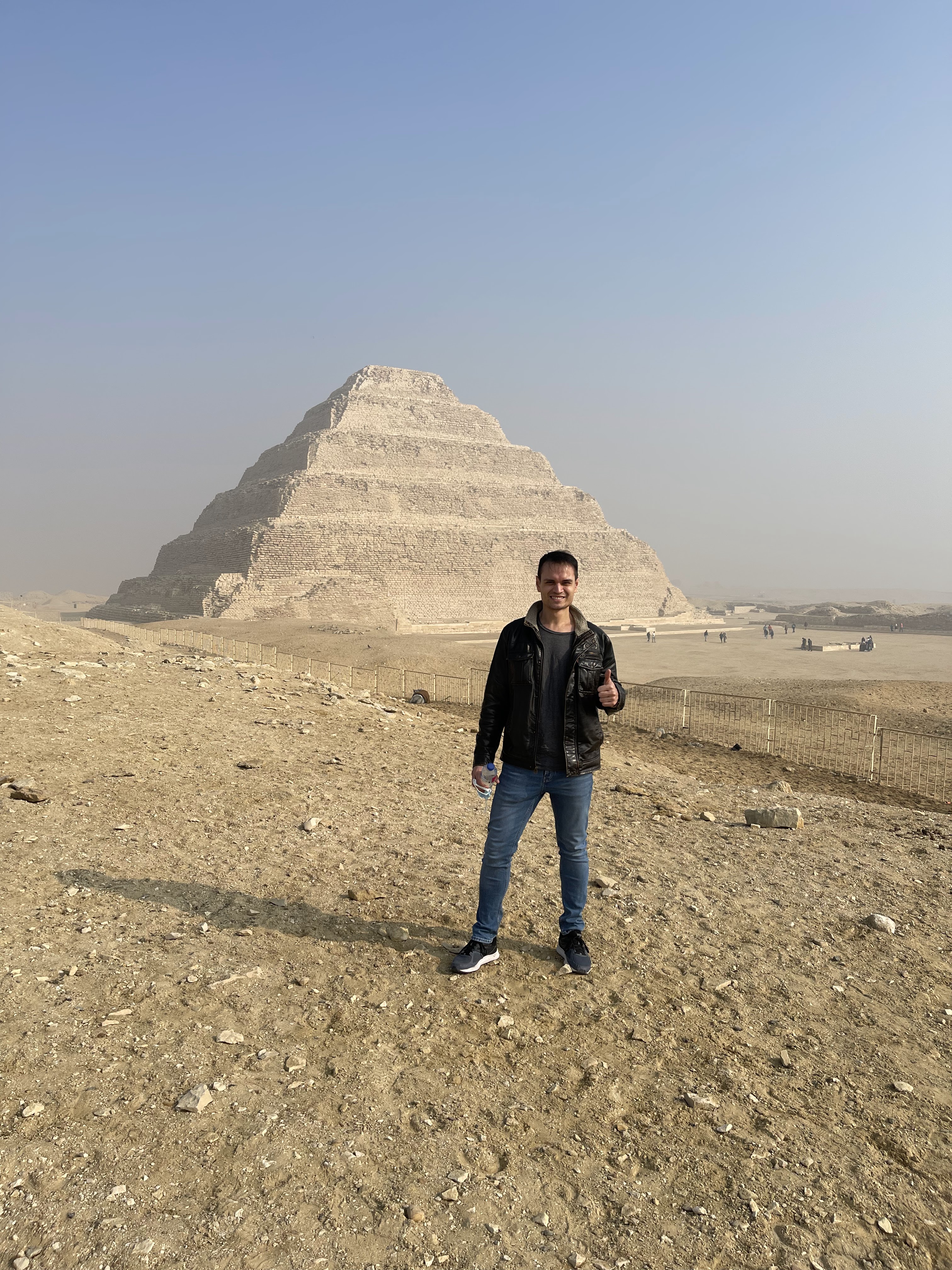 alt="Jontom in front of step pyramid in saqqara Egypt"